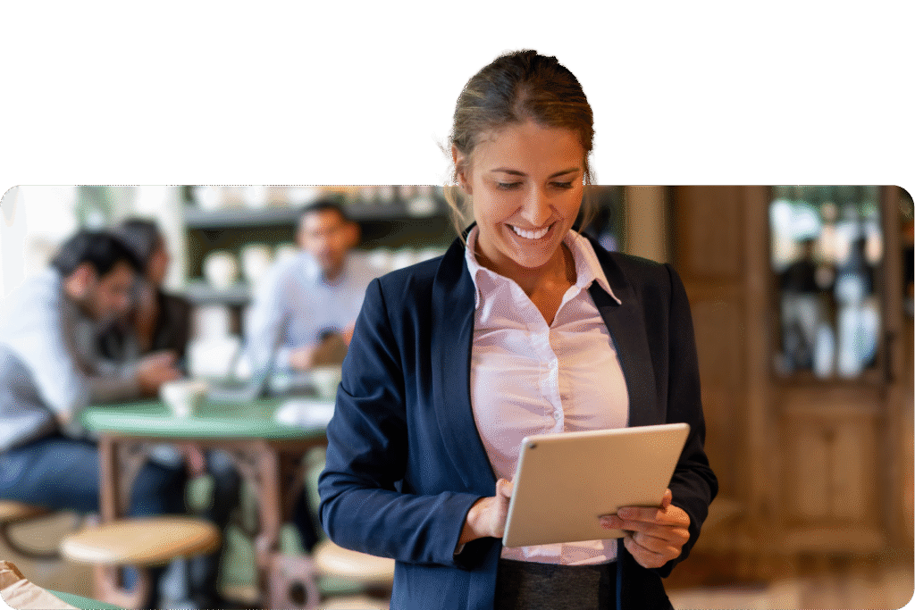 Professional woman smiling at tablet in busy café or restaurant environment